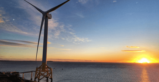 Offshore windturbine against a sunset