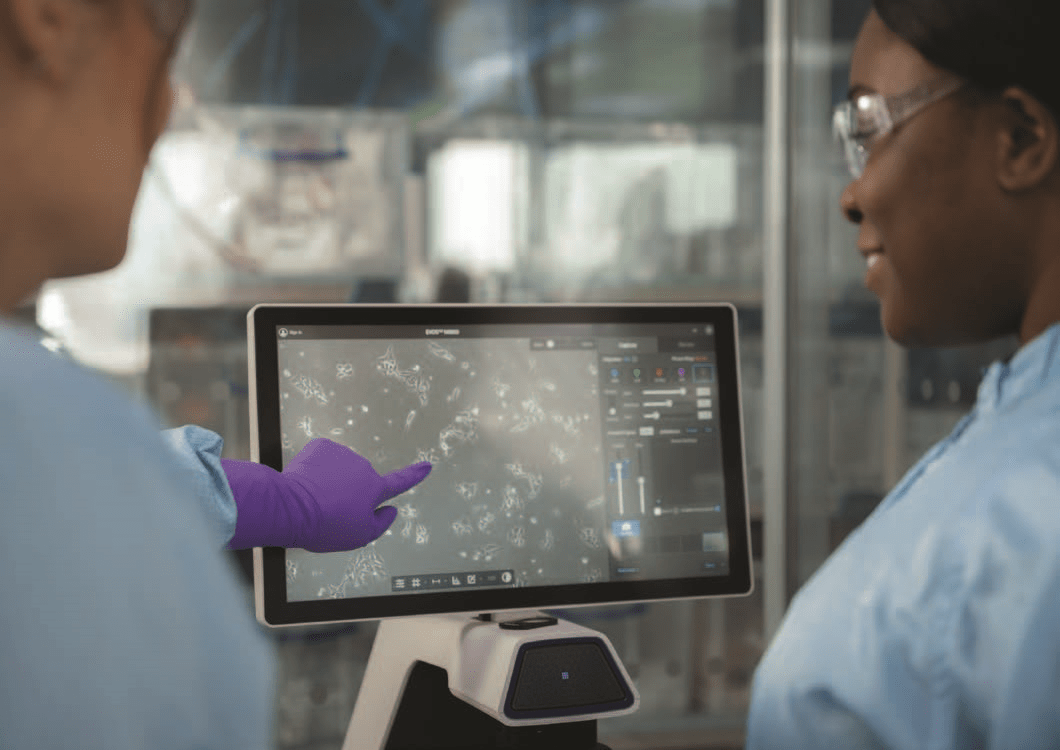 Two lab technicians pointing at a screen