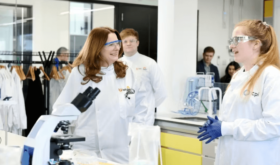 Colleagues wearing lab coats with a microscope 