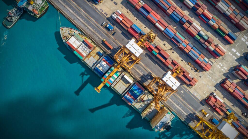 Birds-eye view of freight containers being loaded onto a ship