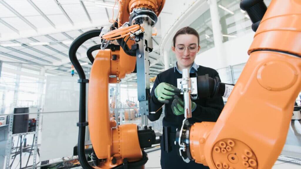 A woman working with a robotic manufacturing machine